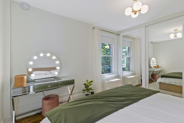 bedroom with hardwood / wood-style floors and a chandelier