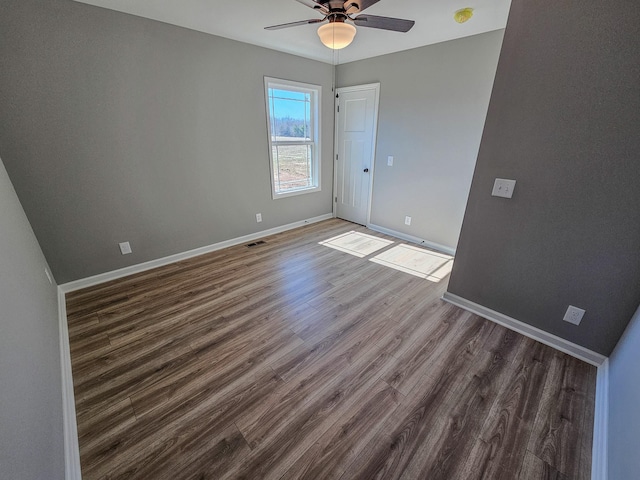 spare room featuring ceiling fan and dark hardwood / wood-style flooring