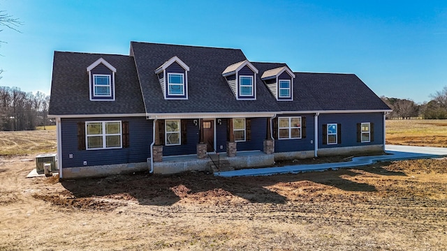 cape cod-style house with central AC and a porch