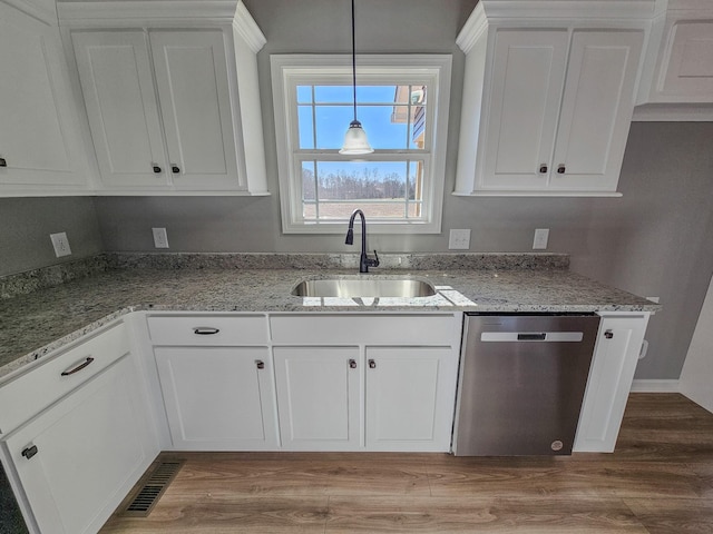 kitchen with sink, white cabinetry, hardwood / wood-style floors, hanging light fixtures, and stainless steel dishwasher