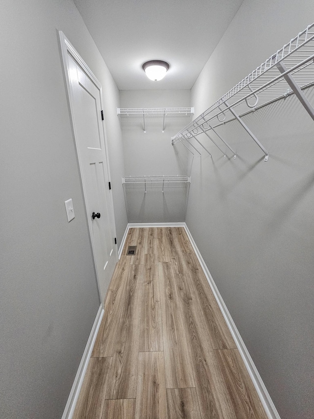 spacious closet with light hardwood / wood-style floors