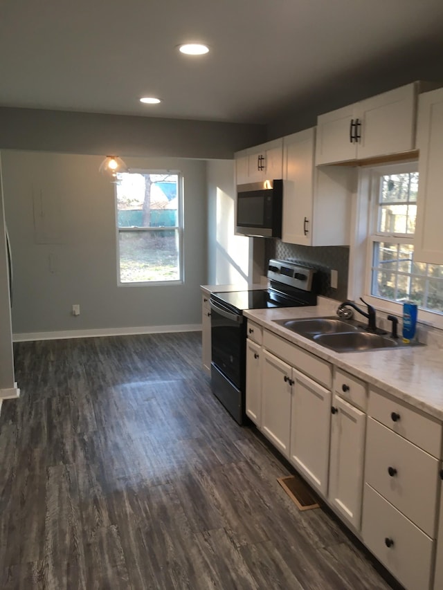 kitchen with white cabinetry, appliances with stainless steel finishes, sink, and backsplash