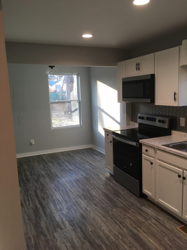 kitchen with electric stove, dark hardwood / wood-style floors, tasteful backsplash, and white cabinets