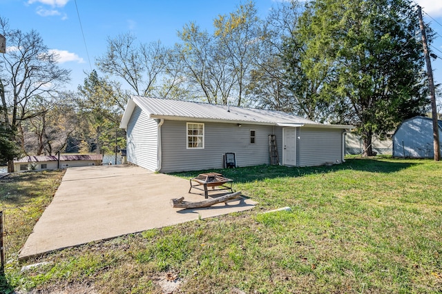 back of property featuring an outdoor fire pit, a patio area, and a lawn