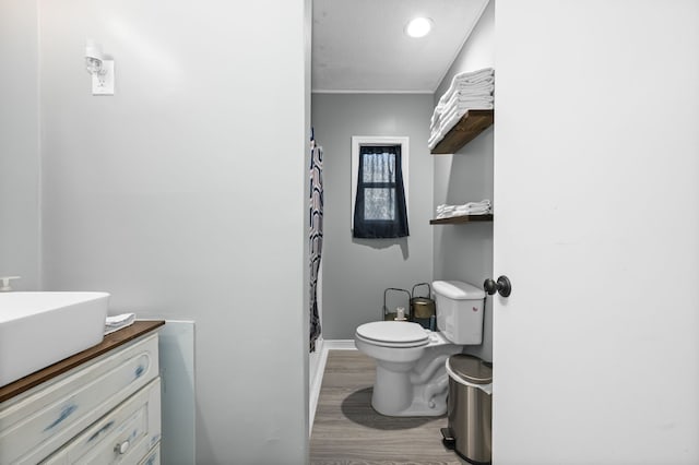 bathroom featuring toilet, vanity, a shower with shower curtain, and hardwood / wood-style flooring