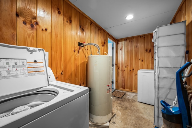 clothes washing area featuring washer / dryer, wood walls, and water heater