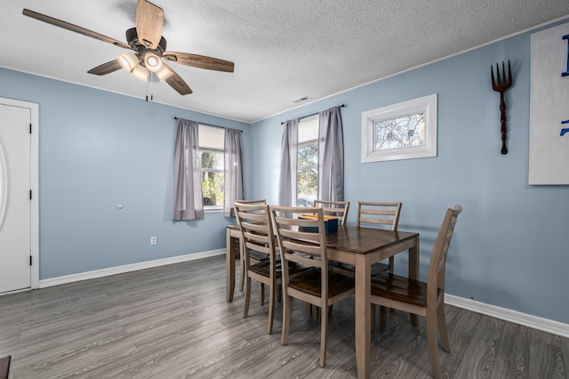 dining room with a textured ceiling, dark hardwood / wood-style flooring, and ceiling fan