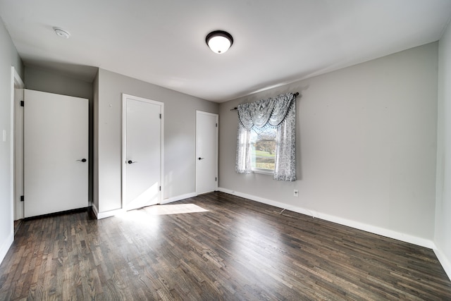 unfurnished bedroom with dark hardwood / wood-style flooring