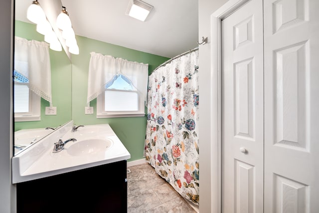 bathroom featuring tile patterned flooring, vanity, and curtained shower