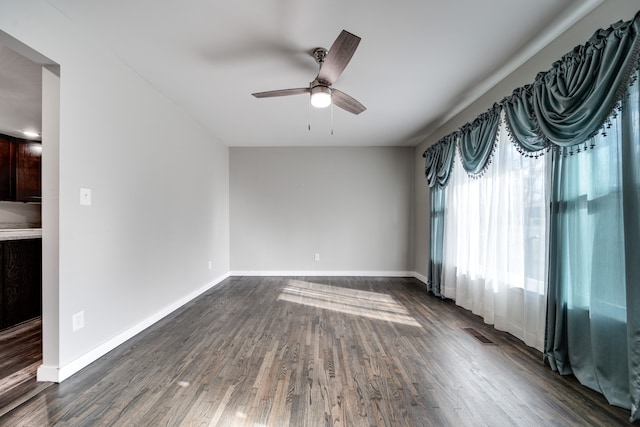 spare room with ceiling fan and dark wood-type flooring