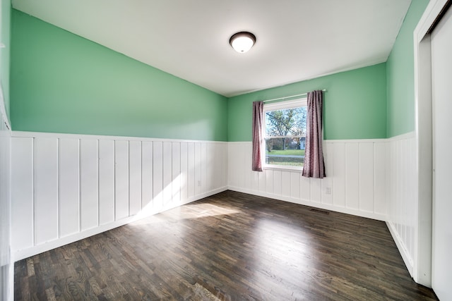 spare room with dark hardwood / wood-style flooring