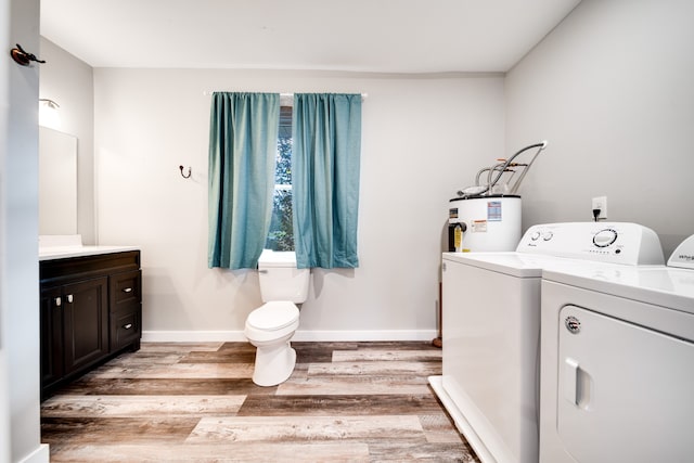 bathroom with hardwood / wood-style floors, vanity, electric water heater, toilet, and separate washer and dryer