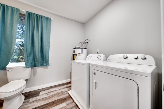 laundry room with hardwood / wood-style floors, washer and dryer, and water heater