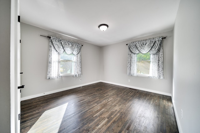 empty room with dark hardwood / wood-style flooring