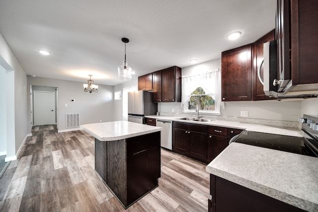 kitchen with a kitchen island, sink, stainless steel appliances, and light hardwood / wood-style flooring