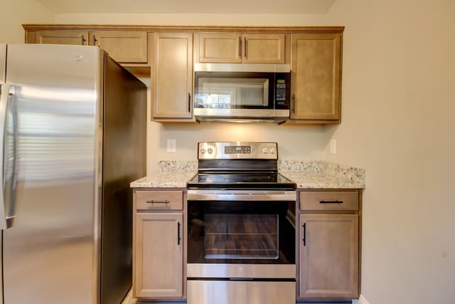 kitchen featuring light stone countertops and stainless steel appliances