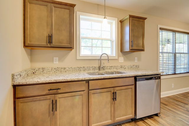 kitchen with sink, stainless steel dishwasher, plenty of natural light, and light hardwood / wood-style flooring