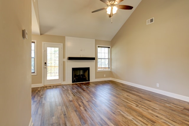 unfurnished living room featuring high vaulted ceiling, ceiling fan, wood-type flooring, and a wealth of natural light