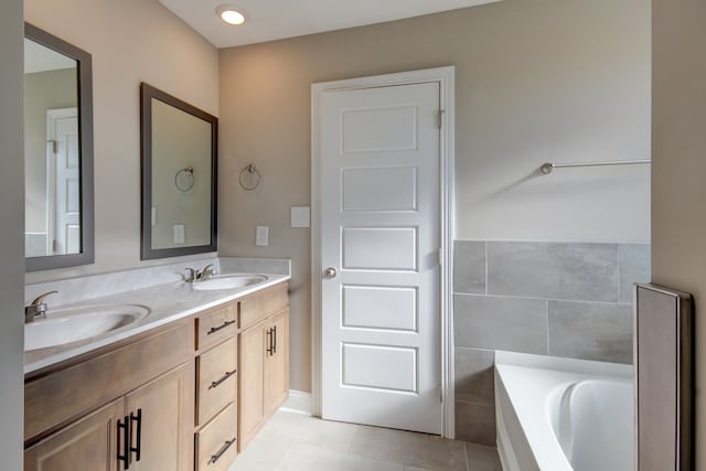 bathroom featuring tile patterned flooring, a bath, vanity, and tile walls