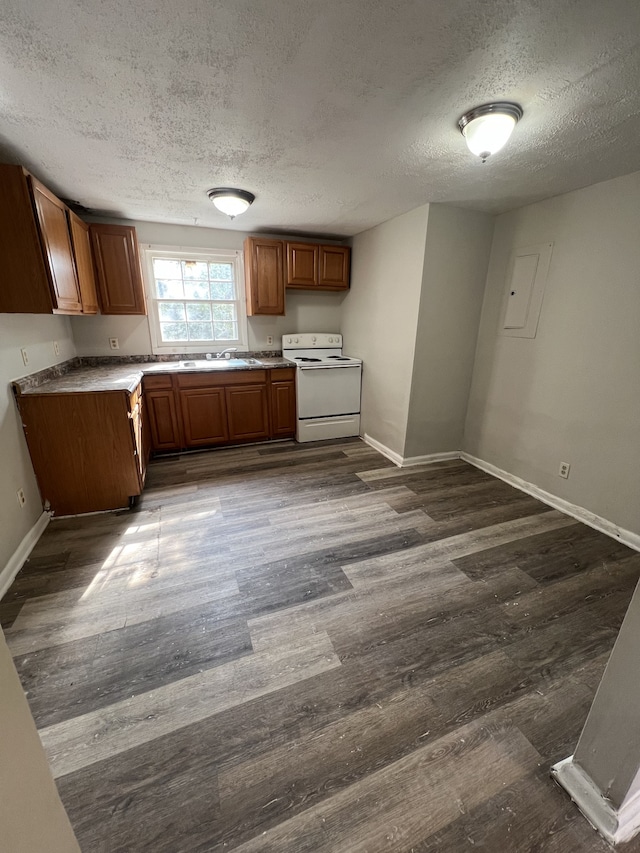 kitchen with white electric range oven, a textured ceiling, dark wood-type flooring, and sink