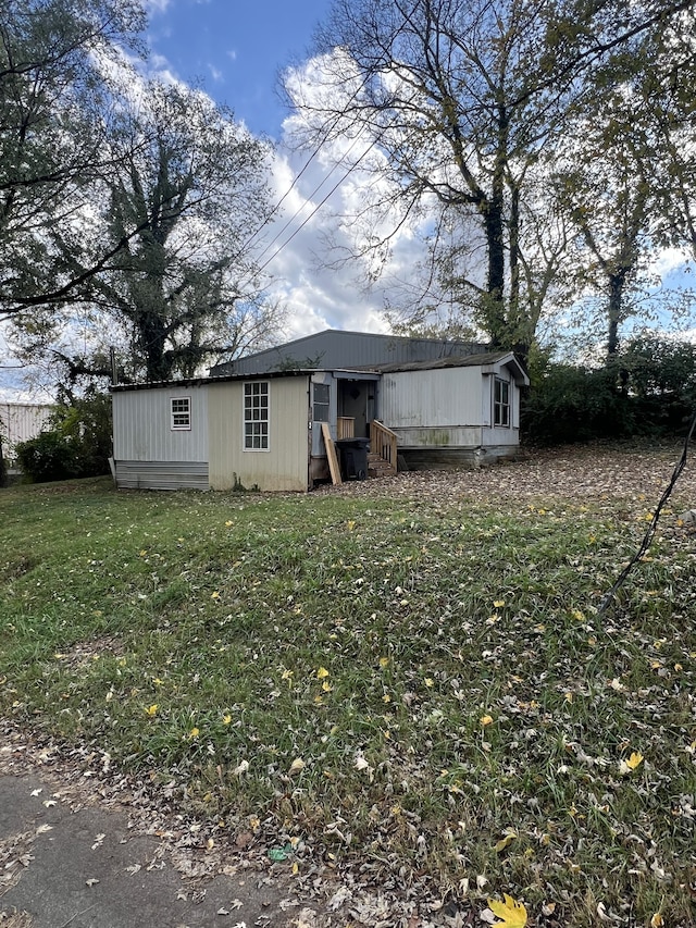 rear view of house featuring a yard