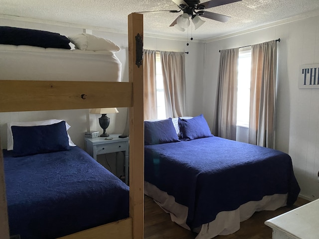 bedroom with hardwood / wood-style floors, a textured ceiling, and ceiling fan