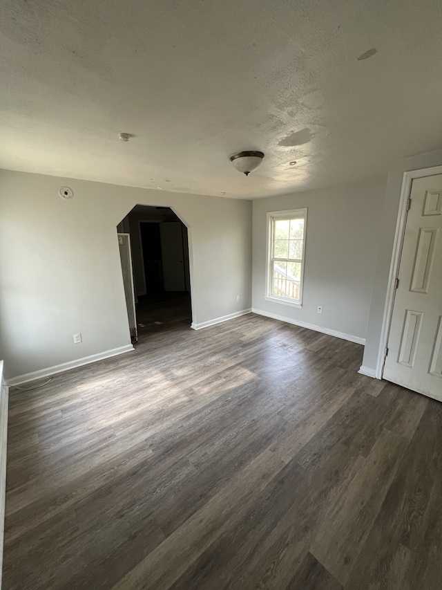 interior space with a textured ceiling and dark hardwood / wood-style floors