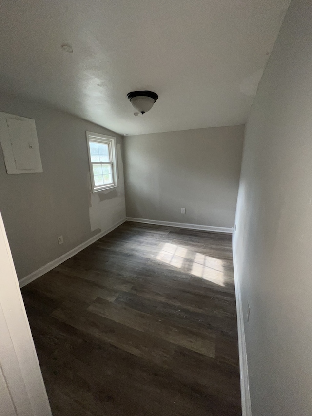 empty room featuring dark hardwood / wood-style flooring and lofted ceiling