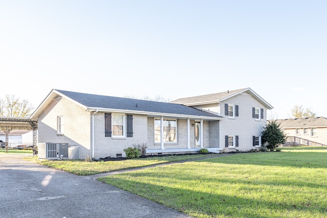 tri-level home with a front lawn and central AC unit