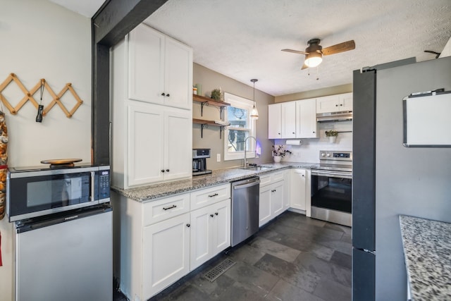 kitchen with sink, white cabinets, decorative light fixtures, and appliances with stainless steel finishes