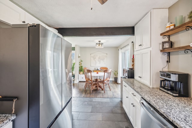 kitchen featuring white cabinets, appliances with stainless steel finishes, and light stone countertops