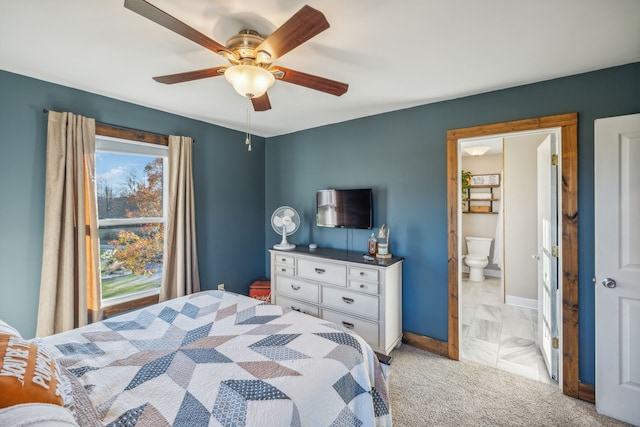 bedroom with light colored carpet, ensuite bath, and ceiling fan