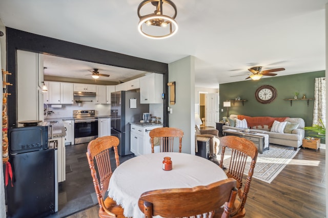 dining room with ceiling fan, dark hardwood / wood-style flooring, and beamed ceiling