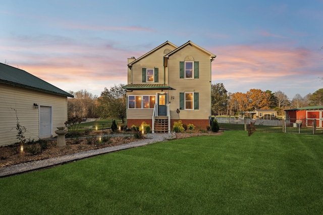 front of property with a lawn and a sunroom