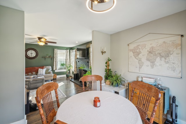 dining space featuring ceiling fan and dark wood-type flooring