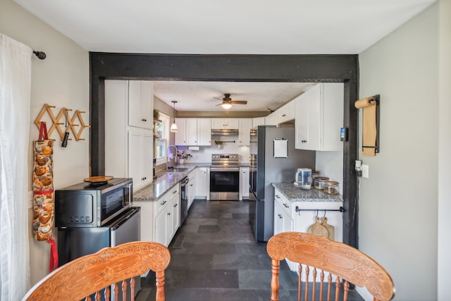 kitchen with ceiling fan, light stone countertops, white cabinetry, and stainless steel appliances