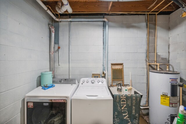 clothes washing area featuring electric water heater and washer and clothes dryer