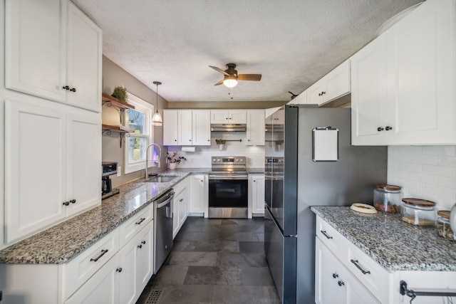 kitchen featuring stone countertops, stainless steel appliances, white cabinetry, and sink