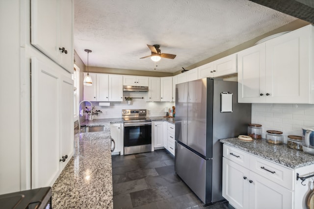 kitchen featuring appliances with stainless steel finishes, light stone counters, a textured ceiling, sink, and white cabinets