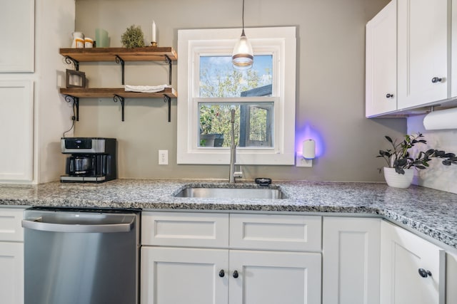 kitchen featuring pendant lighting, white cabinets, sink, stainless steel dishwasher, and light stone counters