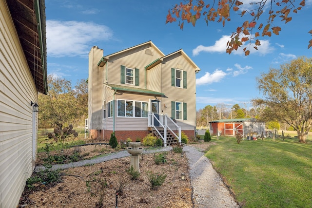 view of front of house featuring an outbuilding and a front yard