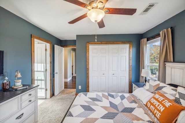 carpeted bedroom with ceiling fan and a closet