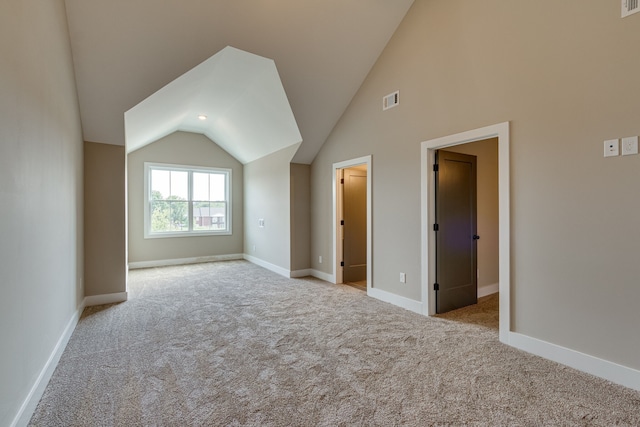 bonus room with light colored carpet and lofted ceiling