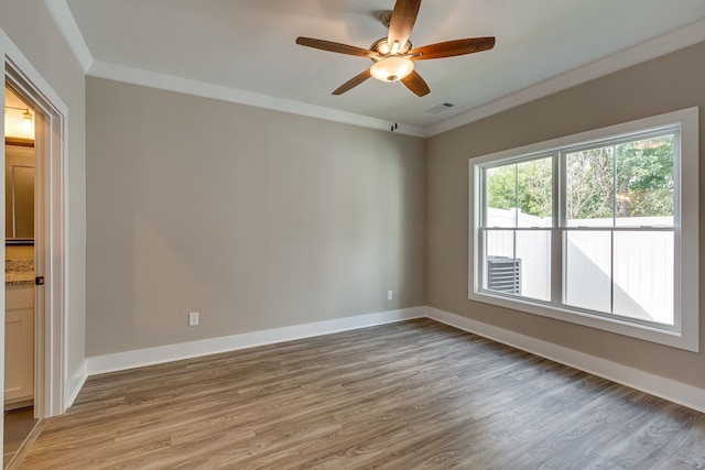 spare room with ceiling fan, light wood-type flooring, and ornamental molding