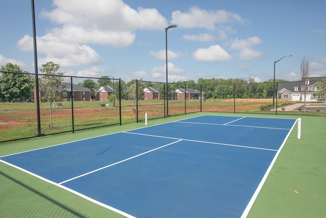 view of tennis court featuring basketball hoop