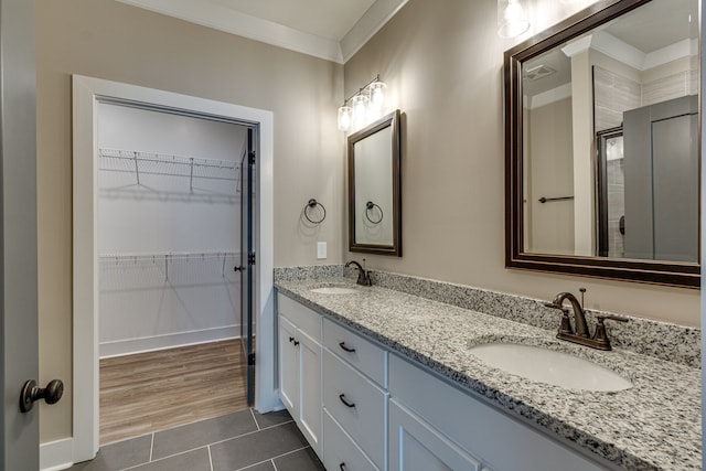 bathroom with crown molding, a shower with door, vanity, and hardwood / wood-style flooring