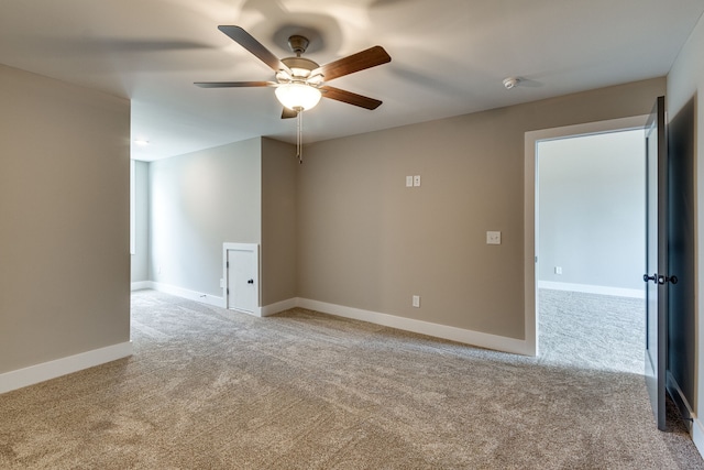 empty room featuring ceiling fan and light colored carpet