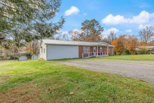 ranch-style home with a porch, a storage unit, and a front lawn