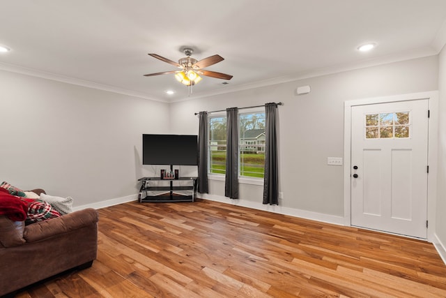 living room featuring ceiling fan, ornamental molding, and light hardwood / wood-style flooring