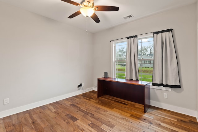 unfurnished office featuring ceiling fan and wood-type flooring